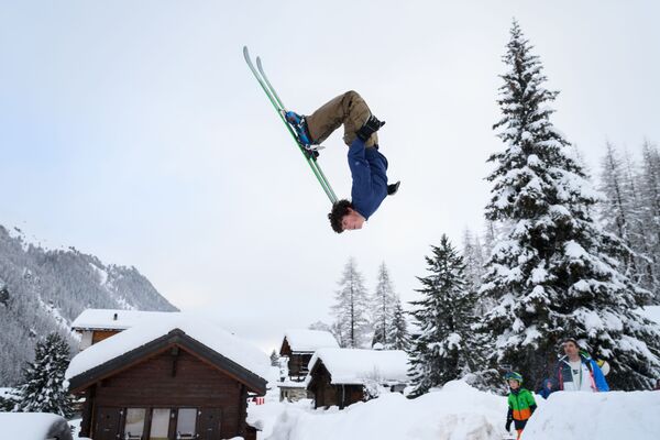 Тинейджер делает кувырок в воздухе на лыжах во время зимнего отдыха в Швейцарских Альпах - Sputnik Азербайджан