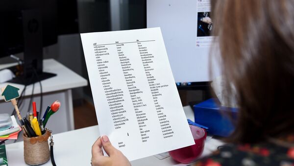 Девушка просматривает лист бумаги со списком слов, скопированных с Орфографического словаря азербайджанского языка - Sputnik Азербайджан