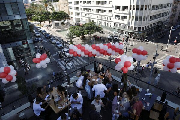 Люди празднуют день рождения своего друга на крыше бара Speakeasy в Тель-Авиве - Sputnik Азербайджан