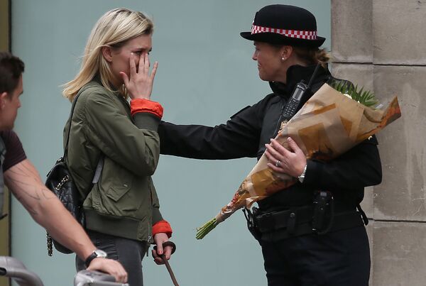 Женщина попросила полицейского возложить цветы у Лондонского моста в память о жертвах теракта 3 июня 2017 - Sputnik Азербайджан