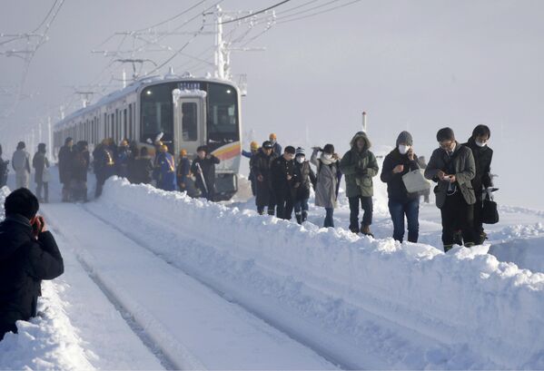 Поезд застрял на перегоне между станциями из-за сильного снегопада в префектуре Ниигата, Япония - Sputnik Азербайджан