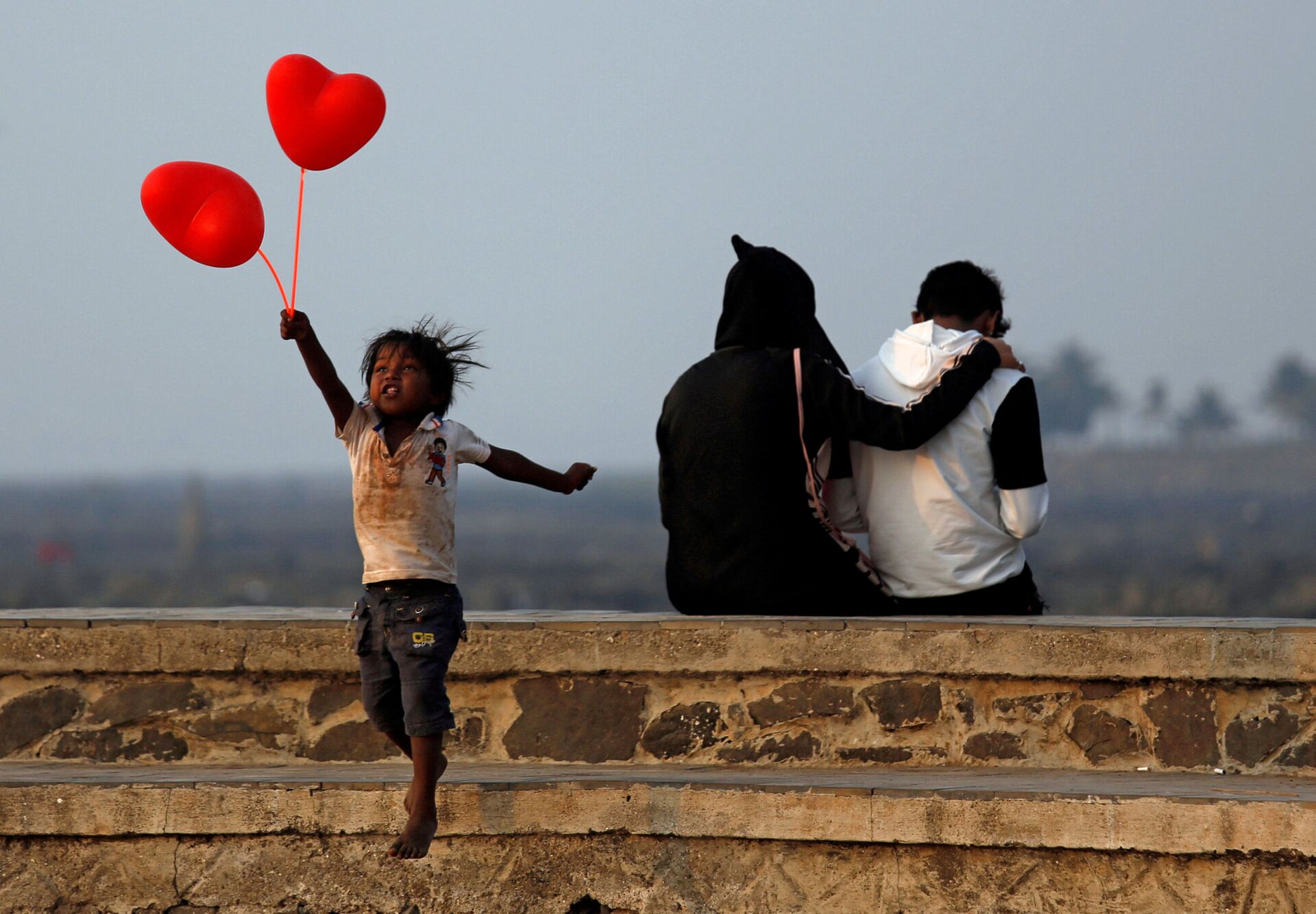 Ребенок с шариками-сердечками и пара на улице Мумбаи в День всех влюбленных - Sputnik Azərbaycan, 1920, 14.02.2022