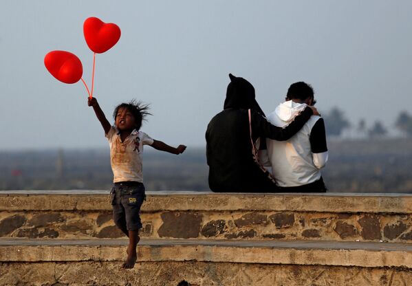 Ребенок с шариками-сердечками и пара на улице Мумбаи в День всех влюбленных - Sputnik Азербайджан