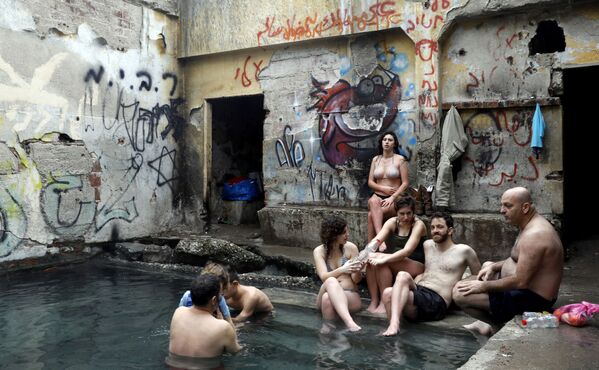 Израильтяне в бассейне с водой из горячих источников в районе спорной территории Голанских высот на границе с Иорданией - Sputnik Азербайджан