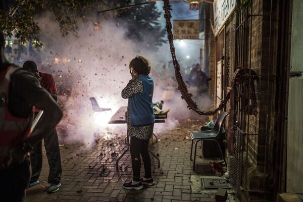 Люди запускают праздничные фейерверки, прогоняющие злых духов, во время празднования Китайского Нового года в Нью-Йорке - Sputnik Азербайджан