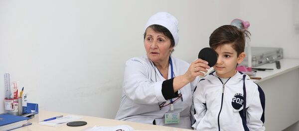 Врач проводит обследование школьника, фото из архива Врач проводит обследование школьника, фото из архива - Sputnik Азербайджан
