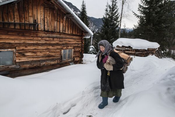 Отшельница из семьи староверов Агафья Лыкова идет с вязанкой дров - Sputnik Азербайджан