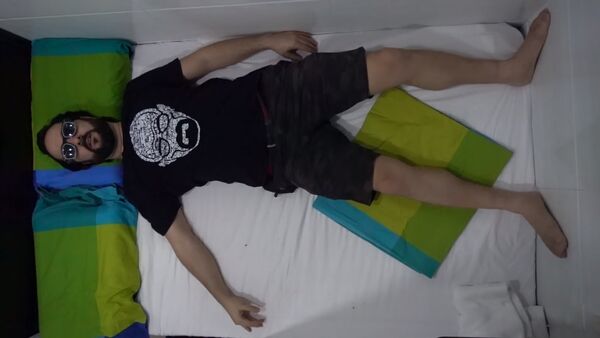 Видеоблогер Ксавье-Джастин лежит на кровати в номере отеля - Sputnik Азербайджан
