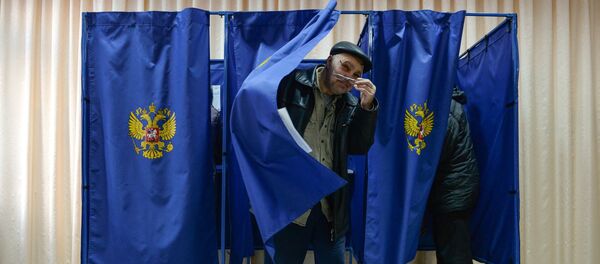 Мужчина выходит из кабинки во время голосования на выборах президента Российской Федерации на избирательном участке в Новосибирске Мужчина выходит из кабинки во время голосования на выборах президента Российской Федерации на избирательном участке в Новосибирске - Sputnik Азербайджан