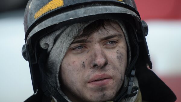 Сотрудник пожарной охраны МЧС во время тушения пожара в торговом центре Зимняя вишня в Кемерово - Sputnik Азербайджан