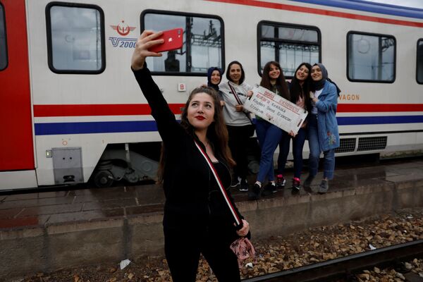 Девушка снимает селфи с подругами на фоне Восточного экспресса, следующего по маршруту из Анкары в Карс, Турция - Sputnik Азербайджан