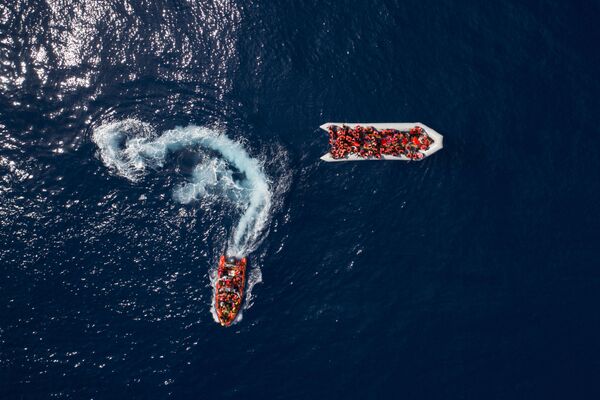 Беженцы и мигранты, спасенные испанской неправительственной организацией ProActiva Open Arms в водах недалеко от севера Ливии - Sputnik Азербайджан