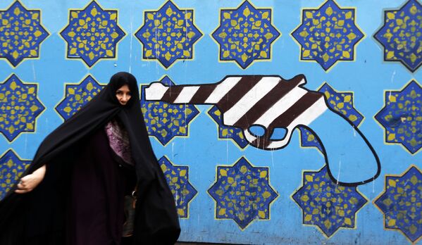 Иранка на фоне граффити у бывшего здания посольства США в Тегеране - Sputnik Азербайджан