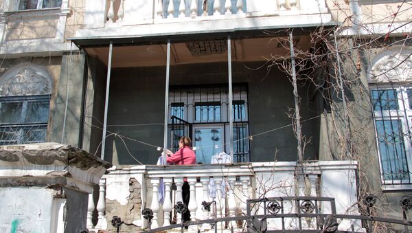 Центр города. Женщина развешивает белье на балконе старинной усадьбы. - Sputnik Азербайджан