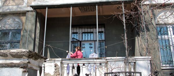 Центр города. Женщина развешивает белье на балконе старинной усадьбы. Центр города. Женщина развешивает белье на балконе старинной усадьбы. - Sputnik Азербайджан