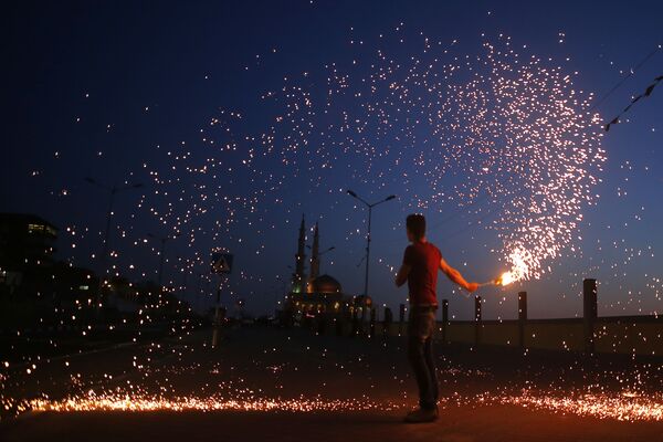 Молодой палестинец с бенгальским огнем накануне страта священного месяца Рамадан в Газе - Sputnik Азербайджан