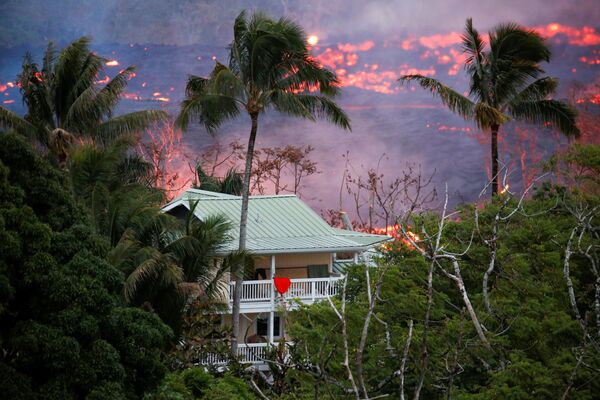 Лава возле дома на окраине Пахоа во время продолжающихся извержений вулкана Килауэа на Гавайях - Sputnik Азербайджан