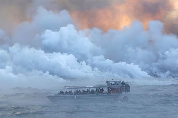 Люди наблюдают с прогулочного судна за тем, как лава из извергающегося вулкана Килауэа на Гавайях достигает Тихого океана - Sputnik Азербайджан