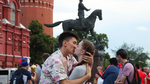 Влюбленные целуются сред болельщиков на Манежной площади в Москве - Sputnik Азербайджан
