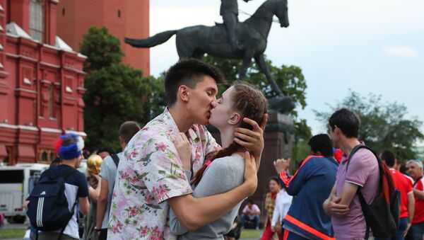 Влюбленные целуются сред болельщиков на Манежной площади в Москве - Sputnik Азербайджан