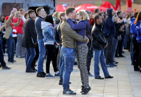 Целующаяся пара в фан-зоне в Екатеринбурге во время вступительного матча между Россией и Саудовской Аравией - Sputnik Азербайджан