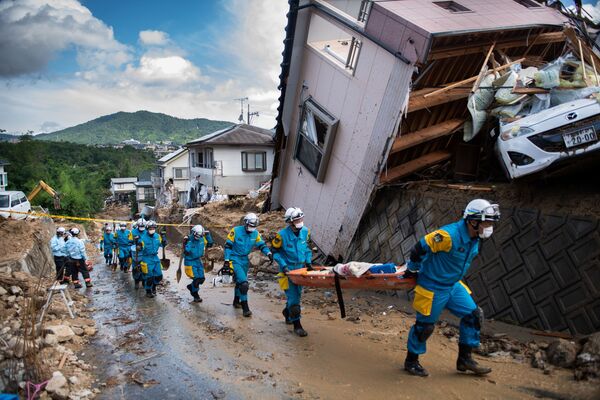 Спасатели и полиция у разрушенных домов в результате ливневых дождей в Японии - Sputnik Азербайджан