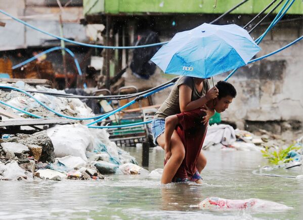 На улице филиппинского города Кесон, затопленной в результате муссонных ливней и тропического шторма Son-Tinh - Sputnik Азербайджан
