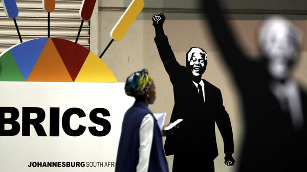Журналист проходит мимо плаката Нельсона Манделы во время саммита БРИКС в Йоханнесбурге, Южная Африка - Sputnik Азербайджан