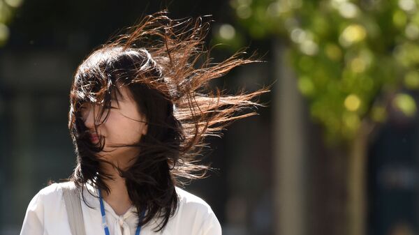 Женщина во время сильного ветра, вызванного тайфуном в Токио, Япония - Sputnik Азербайджан