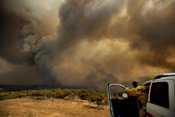 Начальник калифорнийской пожарной части координирует тушение лесных пожаров с вертолетов в районе Лейкпорта, США - Sputnik Азербайджан