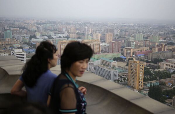 Северокорейские женщины наслаждаются пейзажем с вершины Монумента идей чучхе в Пхеньяне, Северная Корея - Sputnik Азербайджан