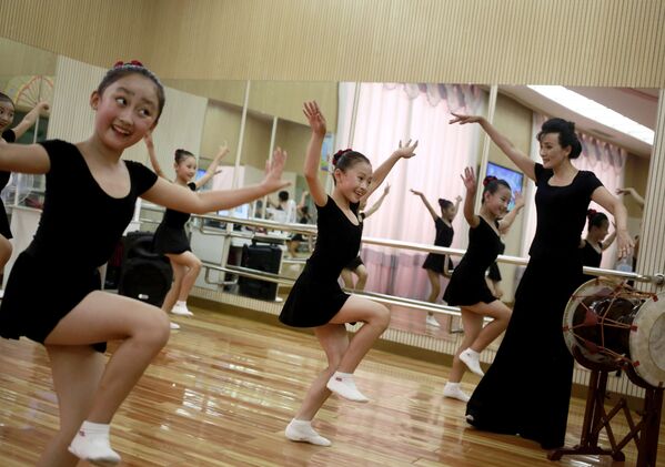 Девочки танцуют в студии во Дворце школьников района Мангендэ в Пхеньяне, Северная Корея - Sputnik Азербайджан