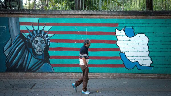 Мужчина проходит перед антиамериканской росписью на стене на одной из улиц Тегерана, фото из архива - Sputnik Азербайджан