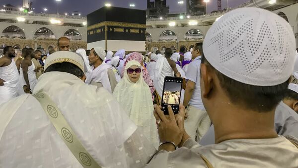 Мусульманские паломники фотографируются перед Каабой в мечети аль-Харам в Мекке, Саудовская Аравия - Sputnik Азербайджан
