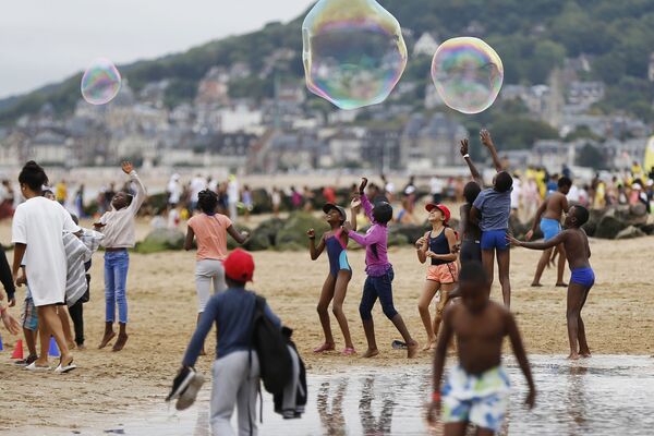 Дети играют на пляже в Кабуре на мероприятии в рамках компании Forgotten by the Holidays, организованной французской неправительственной организацией Secours Populaire для детей, чьи семьи не могут позволить себе отправиться в отпуск, Франция - Sputnik Азербайджан