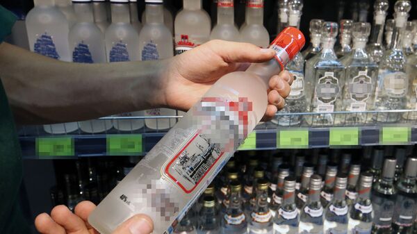 Посетитель держит бутылку водки в магазине, фото из архива - Sputnik Азербайджан