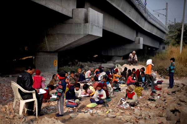 Дети во время урока под железнодоржным мостом в Индии - Sputnik Азербайджан