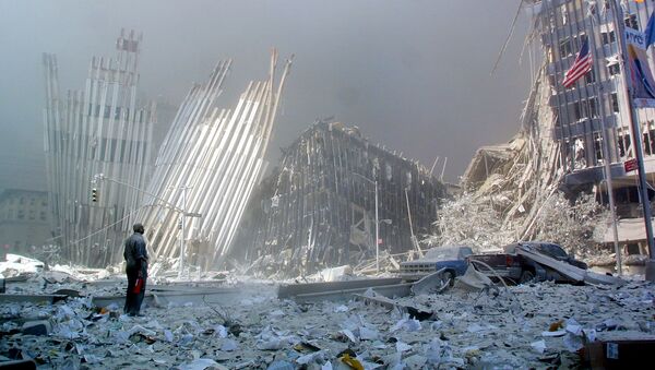 Фото, сделанное 11 сентября 2001 года, человек стоит посреди обломков и спрашивает, нужна ли кому-то помощь после разрушения первой башни Всемирного торгового центра в Нью-Йорке - Sputnik Азербайджан