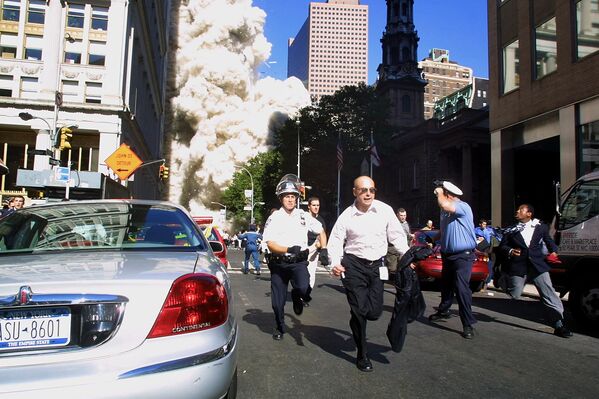 Полицейские и пешеходы убегают во время обрушения башни Всемирного торгового центра 11 сентября 2001 года в Нью-Йорке, США - Sputnik Азербайджан