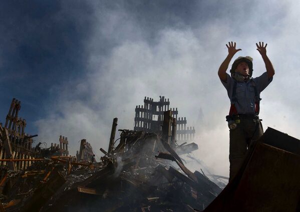 Пожарный зовет на помощ десятерых человек у руин Всемирного торгового центра 15 сентября 2001 года в Нью-Йорке, США - Sputnik Азербайджан
