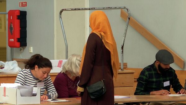 Женщина голосует в одном из избирательных участков Стокгольма, Швеция, 9 сентября 2018 года - Sputnik Азербайджан