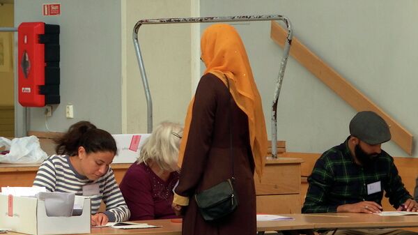 Женщина голосует в одном из избирательных участков Стокгольма, Швеция, 9 сентября 2018 года - Sputnik Азербайджан