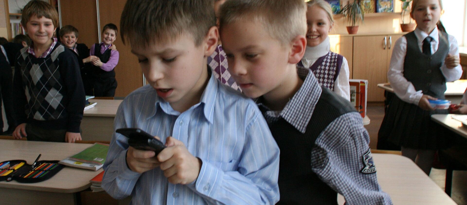 Məktəbli uşaqlar mobil telefonla oynayırlar, arxiv şəkli - Sputnik Azərbaycan, 1920, 04.11.2018