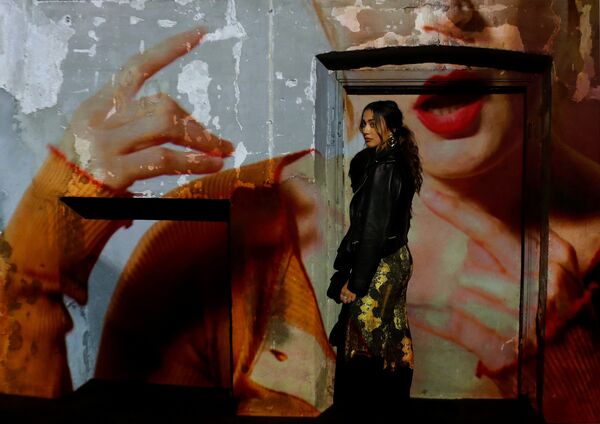 Гостья напротив видеопроекции во время показа мод на Неделе моды Весна/Лето 2019 в Милане - Sputnik Азербайджан