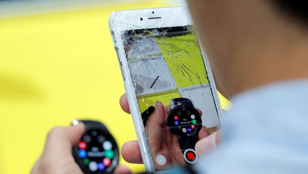 Мужчина снимает айфоном с разбитым экраном новые часы Samsung Galaxy Watch на презентации линейки новых продуктов Samsung в Бруклине - Sputnik Азербайджан