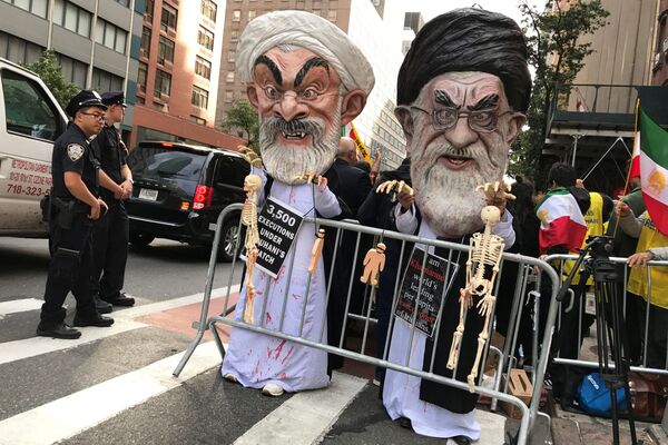 Люди в масках аятоллы Али Хаменеи и президента Ирана Хасана Рухани выступают с протестом против политики Ирана, Нью-Йорк - Sputnik Азербайджан