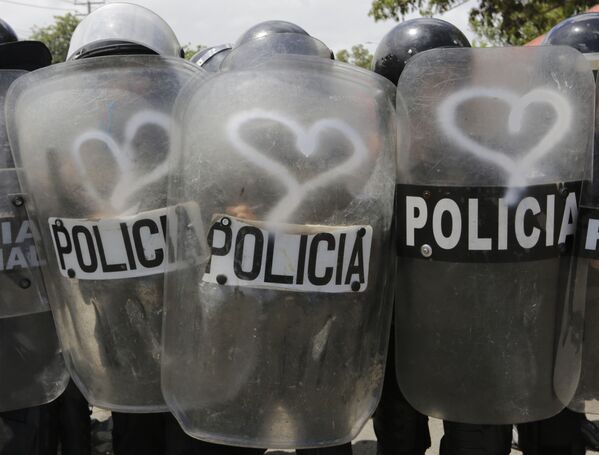 Полиция специального назначения с щитами, изрисованными сердечками, во время столкновения с протестующими против политики президента Никарагуа Даниэля Ортеги в Манагуа - Sputnik Азербайджан