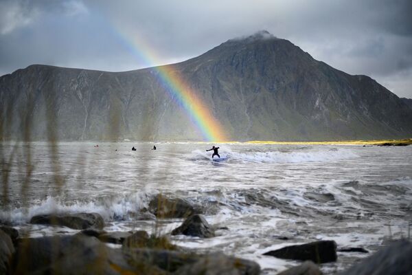 Серфер на фоне радуги в водах коммуны Флакстад на севере Норвегии - Sputnik Азербайджан
