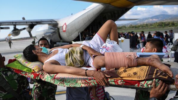 Эвакуация раненных после землетрясения и цунами в аэропорту города Палу , остров Сулавеси , Индонезия - Sputnik Азербайджан