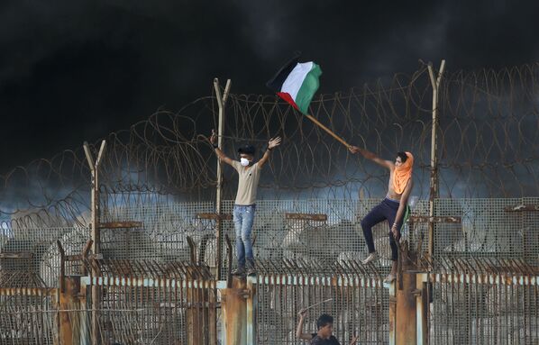 Протестующие палестинцы на металлическом заграждении у прибрежной границы между Израилем и Сектором Газа - Sputnik Азербайджан